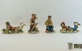 Four Capodimonte Figurines One featuring a young scholar reading a book.