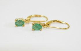 Pair of Emerald Drop Earrings, oval cut solitaire emeralds, totalling 1ct,