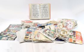 Large box of assorted packets of stamps withc covers, a catalogue and the like.