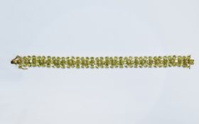 Peridot Flower Line Bracelet, each flower comprising six pear cut peridots centred by a white topaz,