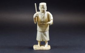 Chinese Ivory Figure of a Man about to hit a fish with a stick; mounted on a bone base; 6 inches