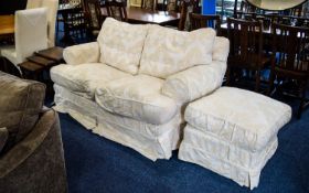 Two Seater Sofa Upholstered in removable cream toned jacquard fabric with woven heraldic design.