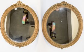 Pair Of Oval Ornate Framed Gilt Mirrors Two mirrors with decorative molded frames.