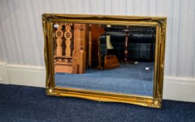 Bevelled Glass Mirror Wall mounted in rectangular classical style yellow gilt frame.