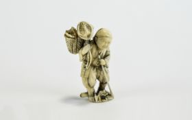 Ivory Figural Netsuke, showing a man walking along with a staff,