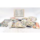 Large box of assorted packets of stamps with covers, a catalogue and the like. Over £40 worth of