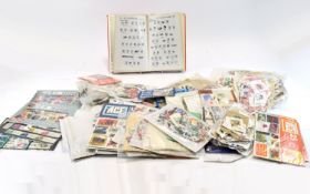Large box of assorted packets of stamps with covers, a catalogue and the like. Over £40 worth of