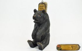 A Black Forest Carved Bear with a brush holder and glass eyes. 8.25 inches high, Designed to be hung