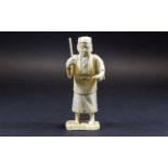 Chinese Ivory Figure of a Man about to hit a fish with a stick; mounted on a bone base; 6 inches