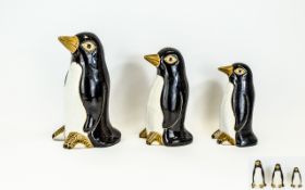 Family of Earthenware Penguins comprising three standing figures of graduated size, hand painted,