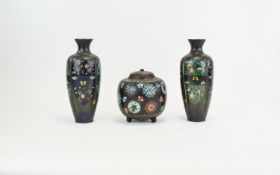 Three Piece Oriental Cloisonne Set Comprising A Lidded Jar Raised On Three Ball Feet And A Pair Of