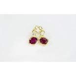 Ruby Pair of Drop Earrings, each having a bezel set, oval cut ruby of 2.