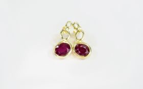 Ruby Pair of Drop Earrings, each having a bezel set, oval cut ruby of 2.