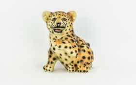 Ceramic Cheetah Cub Figure Playful Cheetah figure with open mouth and raised paw.