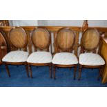 Dining Chairs A set of four dark wood dining chairs with oval woven cane headrests,