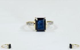 9ct Gold Dress Ring Set With A Central Black Sapphire Between Diamond Chip Shoulders.