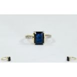 9ct Gold Dress Ring Set With A Central Black Sapphire Between Diamond Chip Shoulders.