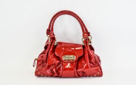 Russell And Bromley Top Handle Turnlock Leather Handbag Fashioned in soft red patent kid leather