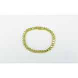 Peridot Tennis Bracelet, a single row of oval cut peridots, totalling 16cts, set, unusually,