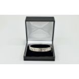 Silver Bangle Hinged bangle with floral and foliate engraving and safety chain. Hallmarked silver.