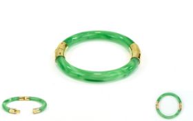 A Mid 20th Century Jadeite Bangle with Unmarked Gold Bands. Nice Condition - Please See Photo.
