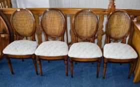 Dining Chairs A set of four dark wood dining chairs with oval woven cane headrests,