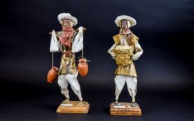 A Pair Of Mexican Glazed Paper Figures Two whimsical figures on square wood bases constructed from