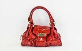 **WITHDRAWN**Russell And Bromley Top Handle Turnlock Leather Handbag Fashioned in soft red patent