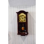 Clock Contemporary wall mounted clock in dark wood effect casing.