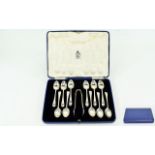 A Boxed Set of ( 11 ) Eleven Teaspoons and Matching Sugar Tongs In Solid Silver.