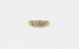 Amethyst and 9ct Gold Ring, a row of four round cut amethysts, each in a square frame, between