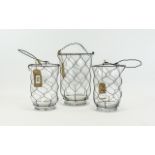 Three Glass And Wire Storm/Garden Lanterns Glass of plain form in descending size order with black
