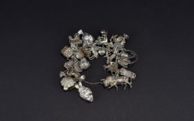 A Vintage And Antique Top Quality Silver Charm Bracelet Loaded with approx 40 old charms,