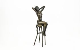Art Deco Style Bronze Sculpture Of A Young Female Nude Hands behind her head seated on a large bar