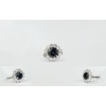 Ladies 18ct White Gold Set Diamond And Sapphire Cluster Ring The central Faceted sapphire