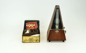 Metronome, teak case and measuring 8.5 inches in height.