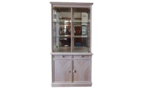 Contemporary Display Cabinet Corner cabinet in pale grey/peach tone wood with two glass front doors,