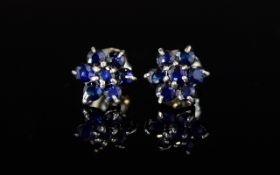 Sapphire Floral Stud Earrings, each earring comprising a flower head made up of seven round cut,