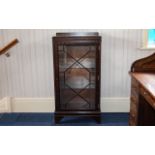 Display Cabinet Dark wood single door cabinet with internal shelves.