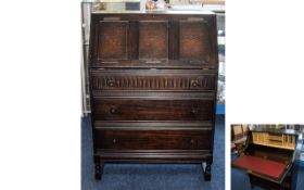 Dark Oak Bureau Three drawer bureau with sloping hinged top section in aged oak.