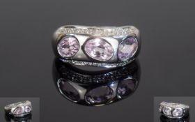 14ct White Gold Dress Ring, Set With Three Oval Amethysts Between Two Rows Of Round Cut Diamonds,
