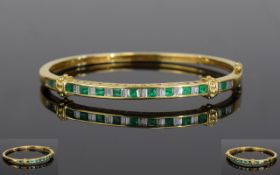 18ct Gold Diamond And Emerald Bangle, The Front Set With 24 Alternating Baguette Cut Diamonds And 11