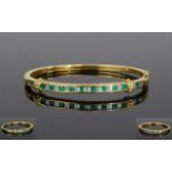 18ct Gold Diamond And Emerald Bangle, The Front Set With 24 Alternating Baguette Cut Diamonds And 11