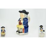 Early 19th Century Period Ralph Wood Type Toby Jug, seated, wearing a black hat, blue coat and