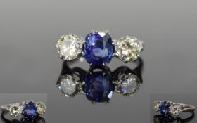 A Fine Platinum Set 3 Stone Diamond and Sapphire Ring. From the 1950's. The Central Blue Sapphire