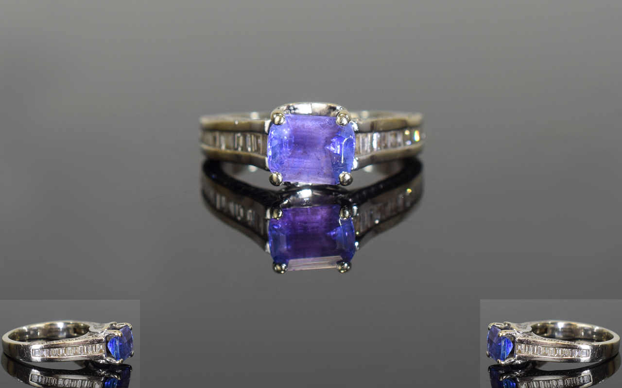 18ct White Gold Single Stone Tanzanite and Baguette Cut Diamond Ring. The Emerald Cut Tanzanite