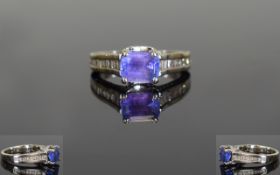 18ct White Gold Single Stone Tanzanite and Baguette Cut Diamond Ring. The Emerald Cut Tanzanite