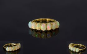 Opal Seven Stone Band Ring, a row of seven oval cut opal cabochons, curving across the finger, set