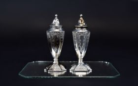A Fine Pair of 1950's Silver Pepperettes of Tapered Form with chased decoration raised on web