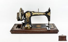 Antique Sewing Machine. Housed in original wood carry case. Produced by 'Jone's', model 'Medium